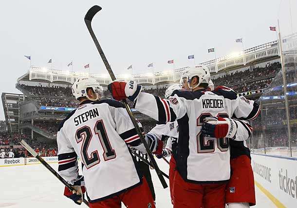 Derek Stepan and the Rangers celebrate a goal against the Devils at Yankee Stadium.